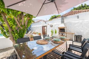 a patio with a table and chairs and an umbrella at La Huertita de Arona Tenerifesummervillas in Arona