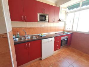 kuchnia z czerwonymi szafkami i zlewem w obiekcie Apartamento Juan Bautista w Maladze