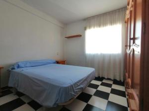 sypialnia z łóżkiem i szachownicową podłogą w obiekcie Apartamento Juan Bautista w Maladze