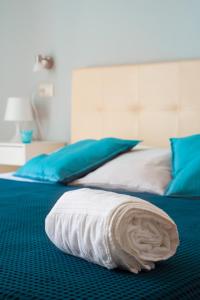 a bed with a white blanket on top of it at Vico 22 Rooms Napoli in Naples