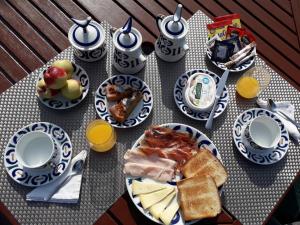 uma mesa coberta com pratos de comida e sumo de laranja em Casa Estarque em Gondomar