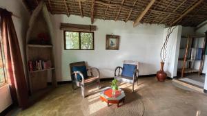 ブウェワウにあるBellevue Zanzibarの椅子、テーブル、花瓶付きの部屋
