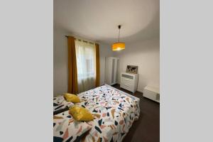 een slaapkamer met een bed met een dekbed erop bij Red lights grand appartement in Saint-Étienne