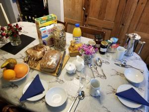 una mesa con un mantel blanco con comida y flores en Cranberry Cottage en Wallingford