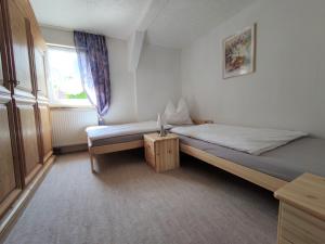 niewielka sypialnia z łóżkiem i oknem w obiekcie Sirisferienhaus w mieście Kurort Steinbach-Hallenberg