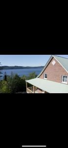 a picture of a house with a view of the water at la belle vue des battures Saguenay Labaie ,qc in Saguenay