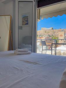 a bedroom with a bed with a view of a balcony at Acropolis Exceptional View II in Athens
