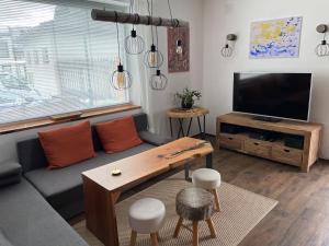 salon z kanapą i telewizorem w obiekcie Kunstwerk AppARTement w mieście Sankt Michael im Lungau