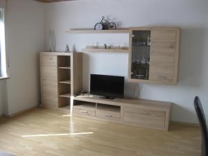 a living room with a television on a wooden cabinet at Haus Weißbrod in Essingen