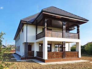 una grande casa bianca con un ampio ponte di Pensiunea Casa Doamnei a Tămaia Altre 16 foto