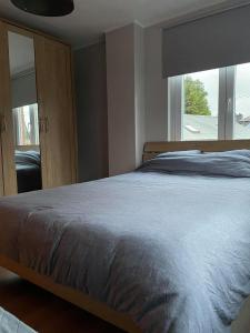 ein Schlafzimmer mit einem Bett und einem großen Fenster in der Unterkunft Maison à deux pas du circuit in Stavelot