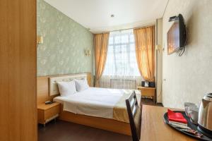 a hotel room with a bed and a window at City Hotel in Moscow