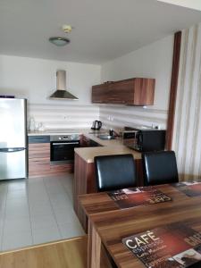 cocina con mesa de madera y nevera en Apartman MARLEA en Donovaly