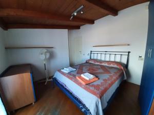 ペーザロにあるCasa Cavourのベッドルーム1室(ベッド1台、テーブル、ファン付)