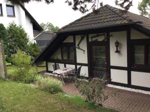 a white and black house with a picnic table in front of it at Ferienhaus und Privatvermietung Andrea Giesecke in Meiningen