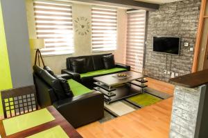 uma sala de estar com cadeiras de couro preto e uma mesa em Apartman stan Luka em Pale