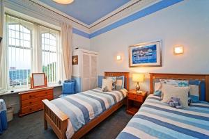a bedroom with two beds and two windows at Glenbervie Guest House in Oban
