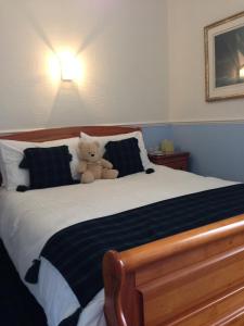
a white teddy bear sitting on top of a bed at Glenbervie Guest House in Oban
