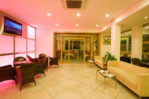 a living room with a couch and tables and chairs at Hotel Desiree in Cesenatico