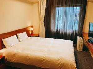 Dormy Inn Kanazawa Natural Hot Spring客房内的一张或多张床位