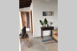 a living room with a table and a television at SERMAR 1 in Rabo de Peixe