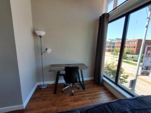 a desk with a chair in a room with a large window at Trendy Midtown Lofts in Cleveland