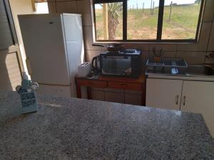 a kitchen with a refrigerator and a counter with a microwave at Non Stop Adventures in Pietermaritzburg