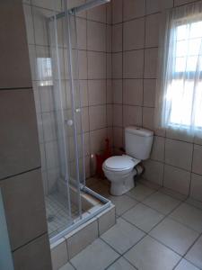 a bathroom with a toilet and a glass shower at Non Stop Adventures in Pietermaritzburg
