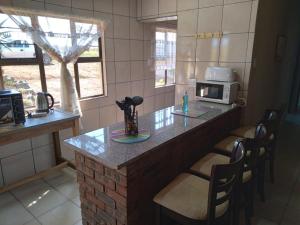 cocina con encimera con sillas y microondas en Non Stop Adventures, en Pietermaritzburg 18 fotos más