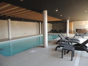 a hotel pool with chairs and a swimming pool at Luxury 2 Bedroom Apartment with view of Mont Blanc in Combloux