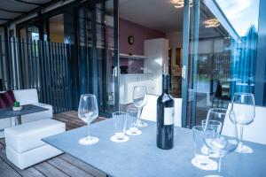 a table with glasses and a bottle of wine on it at Hana - Apartments in Ljubljana