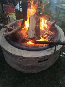 a fire pit with a tree stump in it at By the Bay Cottages in Stanhope