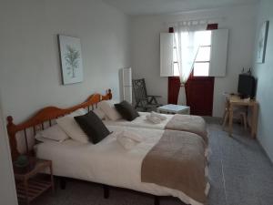 a bedroom with a large white bed with pillows at Apartamentos Playa in Hermigua +13 photos