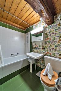 La salle de bains est pourvue d'une baignoire, d'un lavabo et de toilettes. dans l'établissement Chesa La Cuntainta - Sils Maria, à Sils-Maria