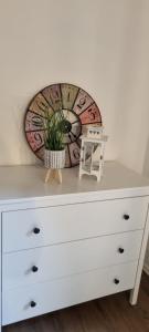 a white dresser with a clock on top of it at Ferienwohnung Spessartbude in Schollbrunn