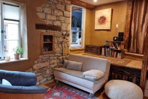 a living room with a couch and a stone wall at Schöne Ferienwohnung mit Kamin in Neustadt an der Weinstraße