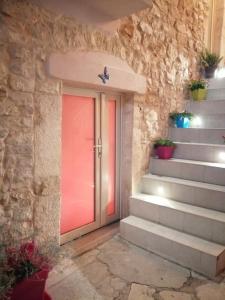 una puerta en una pared de piedra con escaleras con plantas en Casa Giadi', en Cassano delle Murge