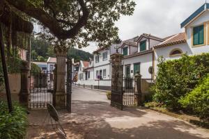 una puerta de hierro en una calle con casas en Moradia no Largo en Furnas