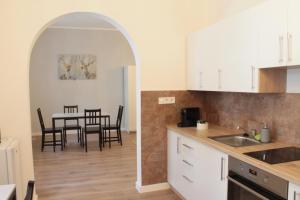eine offene Küche und ein Esszimmer mit einem Tisch in der Unterkunft Zwinger Apartman in Sopron