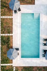 an overhead view of a swimming pool with umbrellas at Irissa Suites in Paralía Iríon