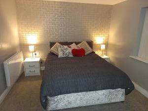 a bedroom with a bed with two lamps and a brick wall at Login house A in Derry Londonderry