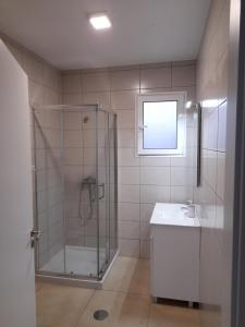uma casa de banho com um chuveiro e um lavatório. em Casa Azul em Porto Santo