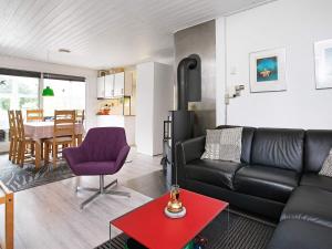 ブラーバンドにあるHoliday home Blåvandのリビングルーム(黒い革張りのソファ、テーブル付)