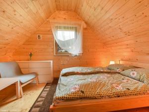 ein Schlafzimmer mit einem Bett in einer Holzhütte in der Unterkunft Nowe domki w górach "Pod Skrzycznym", koło Szczyrku in Szczyrk