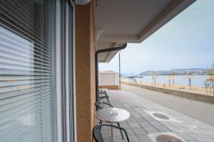 einen Balkon mit Stühlen und einem Tisch sowie Strandblick in der Unterkunft Danubiana Apartments 5 in Kladovo + 12 Fotos