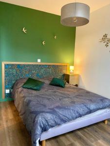 1 dormitorio con 1 cama grande y pared verde en Appartements du 101, en Villeneuve d'Ascq