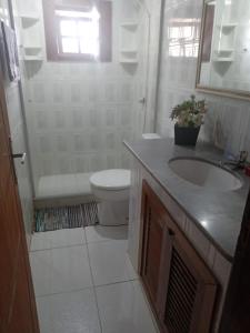 布希奧斯的住宿－Casa de Temporada Centro Búzios，白色的浴室设有水槽和卫生间。