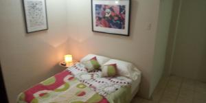 Un pequeño dormitorio con una cama con una vela. en Boel Boutique Suite en Guayaquil, en Guayaquil