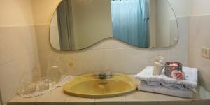 a bathroom with a yellow sink and a mirror at Boel Boutique Suite en Guayaquil in Guayaquil