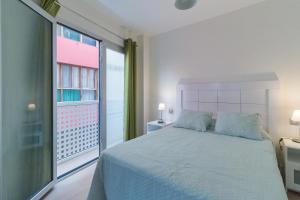 1 dormitorio con cama y ventana grande en New and Cute Studio close to the beach., en Las Palmas de Gran Canaria